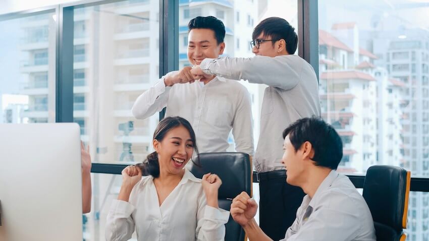 a happy group of colleagues celebrating a work success