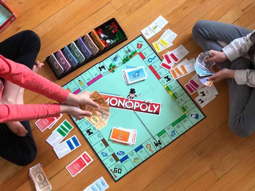 2 people playing the board game Monopoly