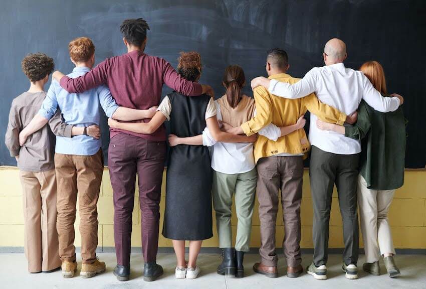 group of people with their arms around each other's shoulders