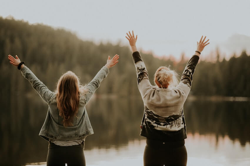 happy women with their arms up in the air