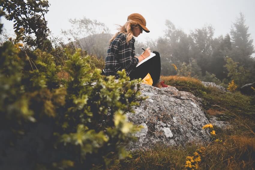 a woman sitting outside, journaling