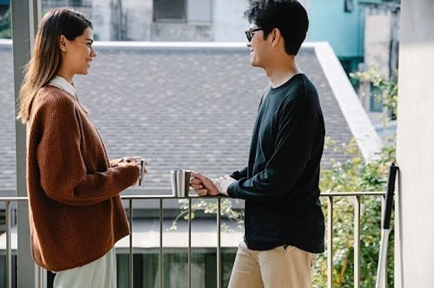 man and woman talking while drinking coffee
