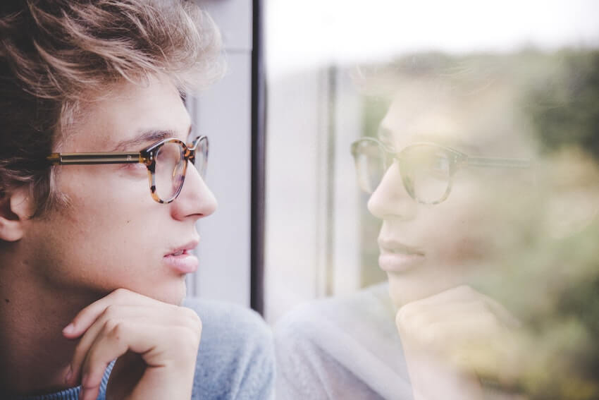 man looking at himself in a window