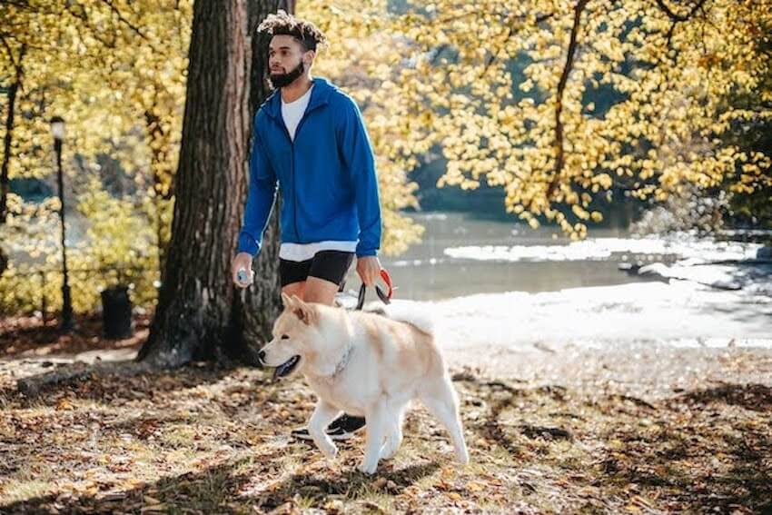 man walking outside with his dog