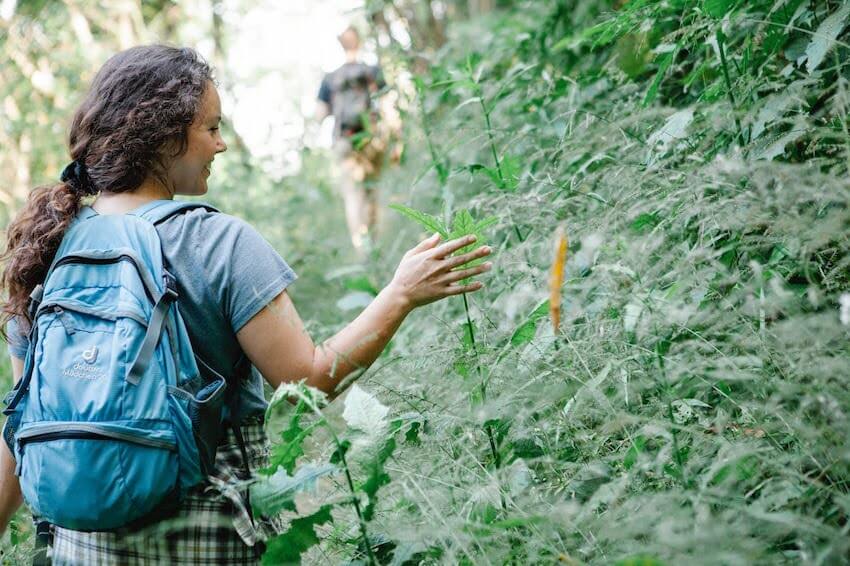 female hiker admiring the plants around her