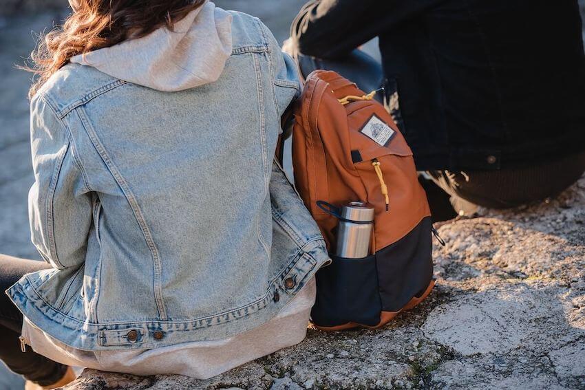 woman with a reusable water bottle in her backpack