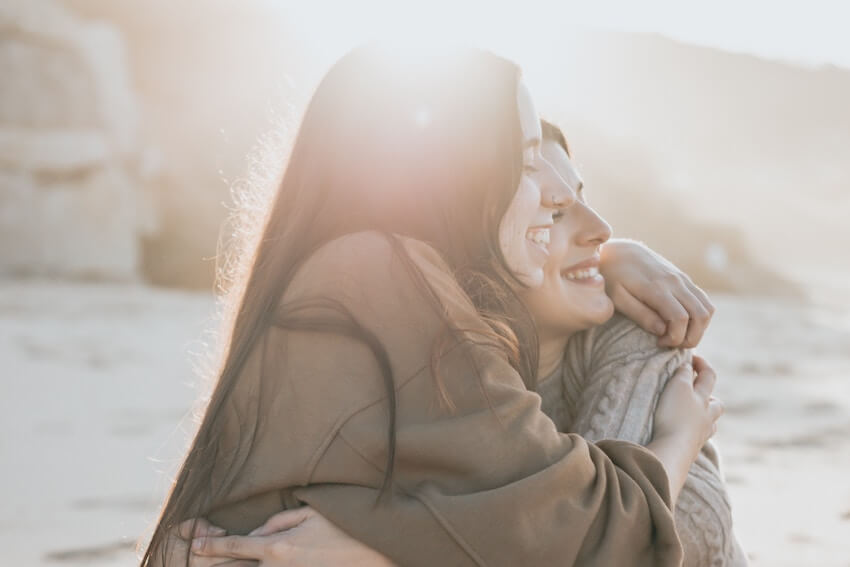 smiling friends in a warm embrace