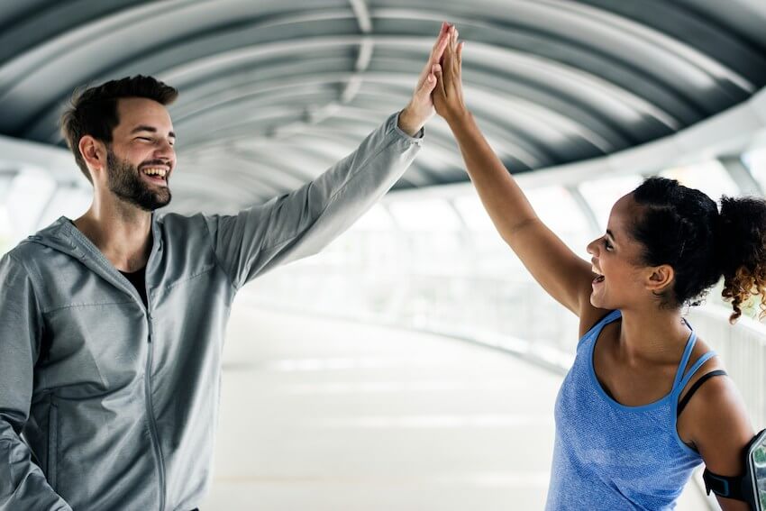 smiling man and woman high fiving each other