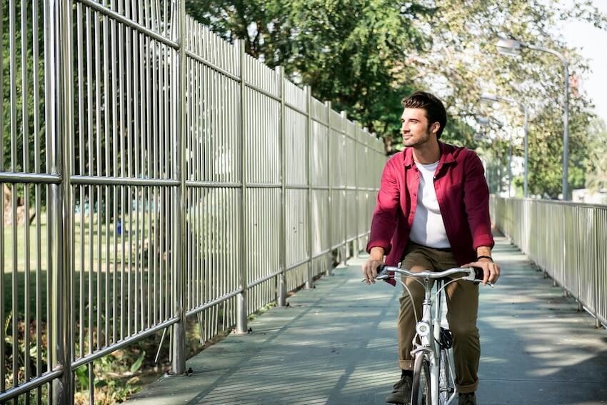 smiling man biking around the neighborhood