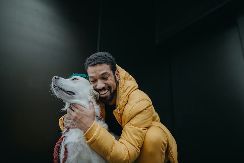 smiling man hugging his dog