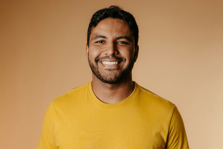 smiling man in a yellow shirt