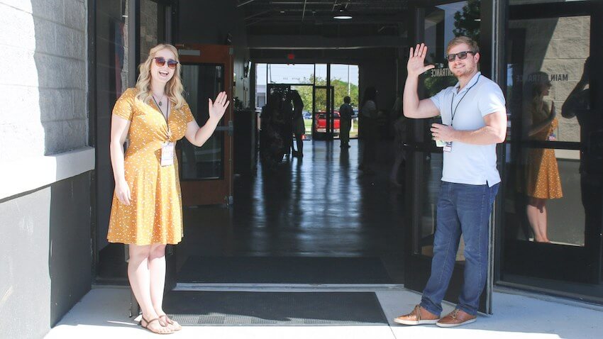 smiling people opening the door and waving hello