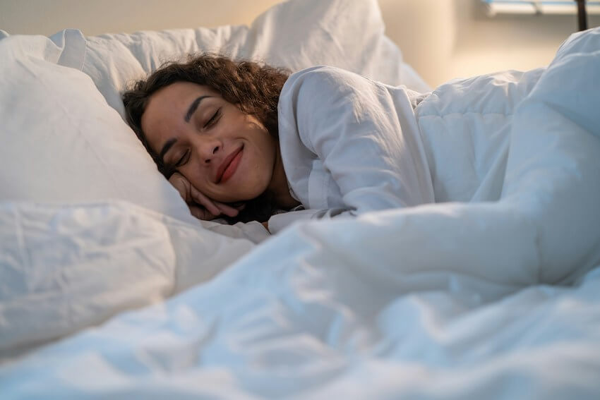 smiling woman asleep in bed