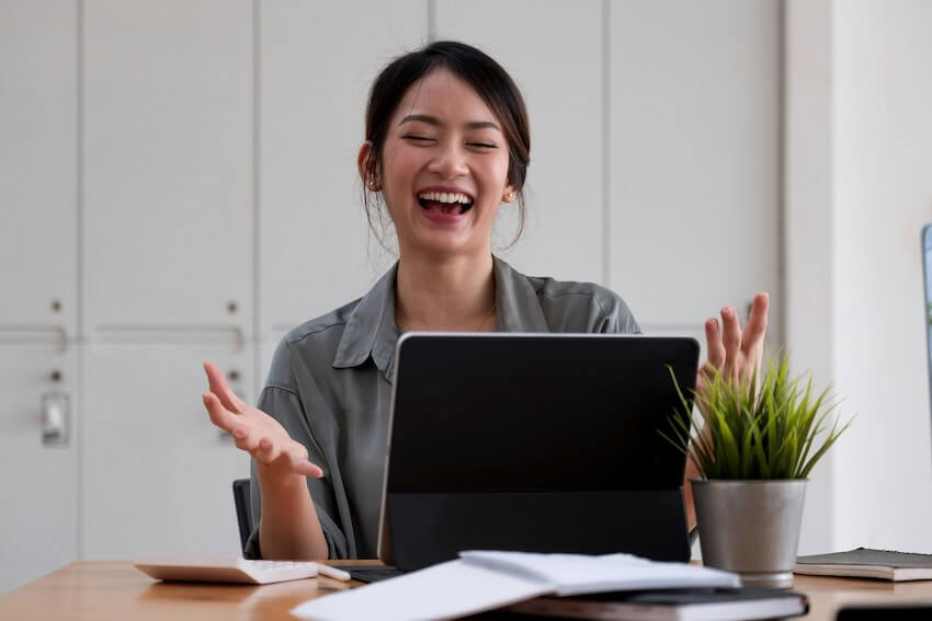 smiling woman talking with her friend on her laptop
