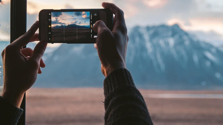 taking a picture of beautiful mountain scenery with a mobile phone