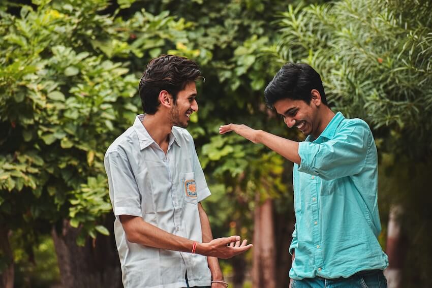 two smiing men high fiving each other