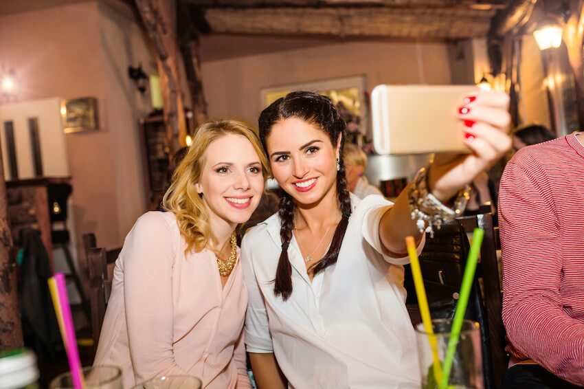 two smiling friends taking a selfie