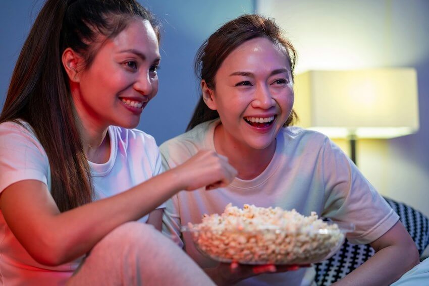 two smiling women enjoying movie night
