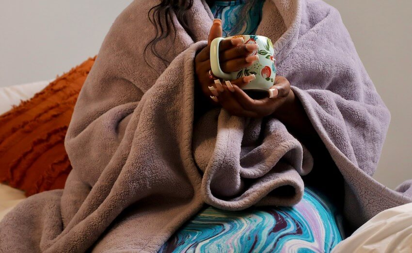 woman drinking from mug with images of various fruits