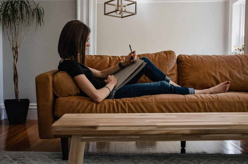 woman journaling on a couch