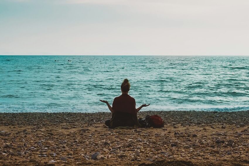 woman meditating on a tranquil beach