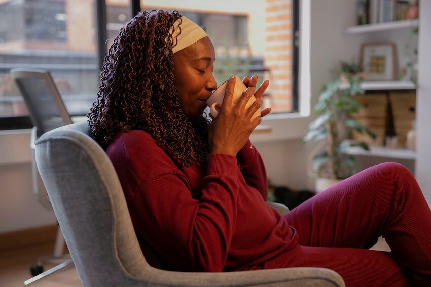 woman savoring a cup of coffee at home