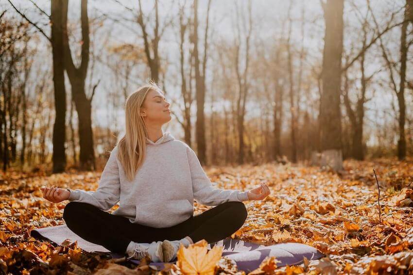 woman meditating outside, soaking in the sun