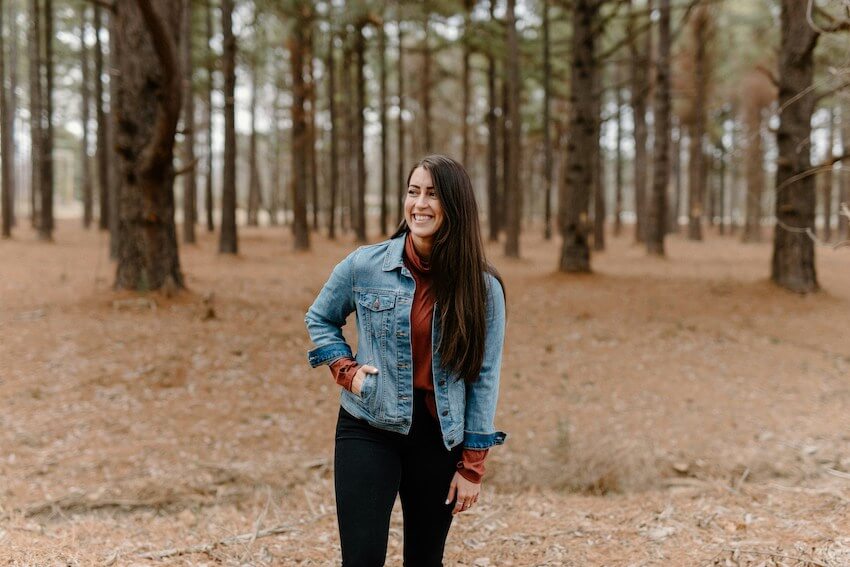 woman smiling while walking in the woods