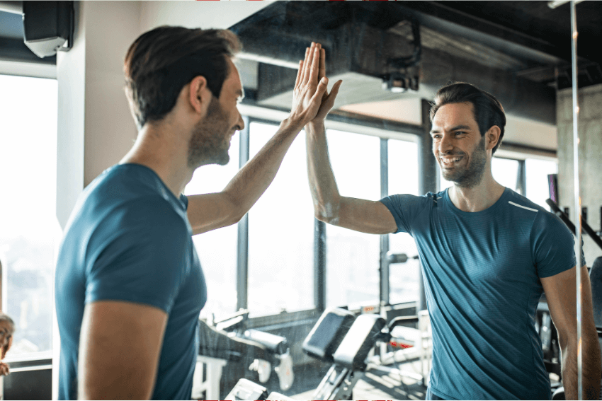 smiling man high fiving himself in the mirror
