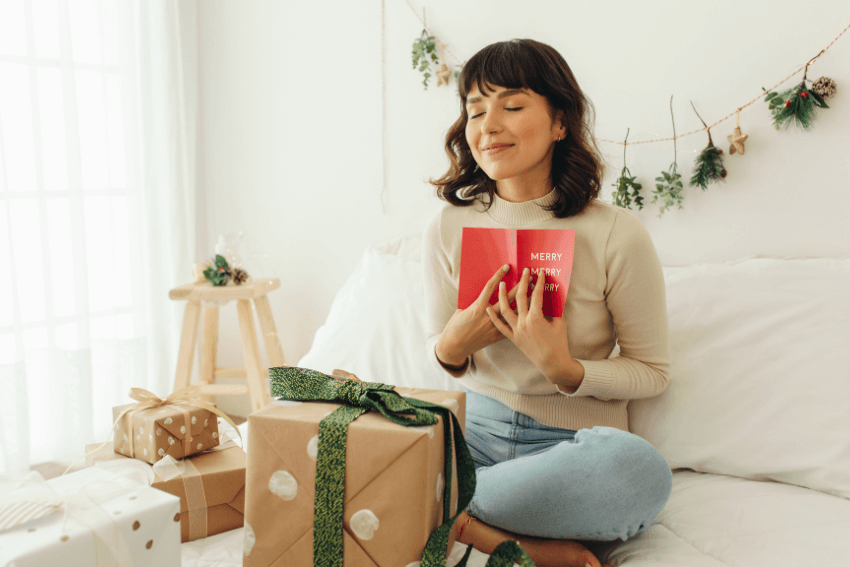 smiling woman holding a holiday card to her chest
