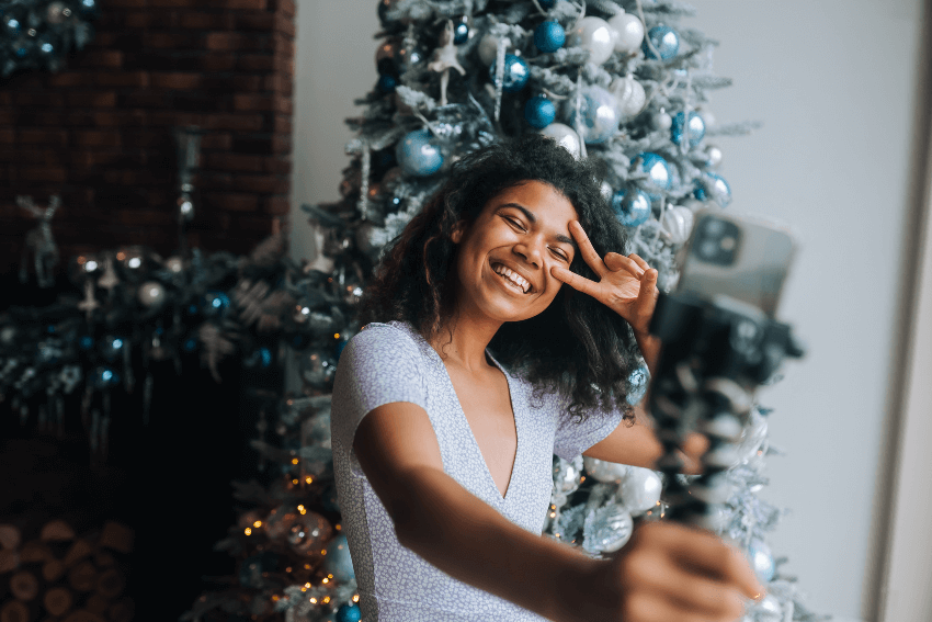 smiling woman recording a video message for the holidays