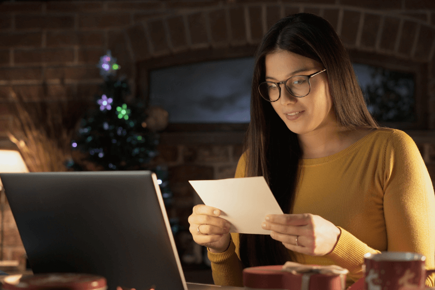 woman in glasses reading a holiday card