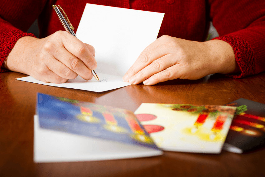woman writing holiday cards