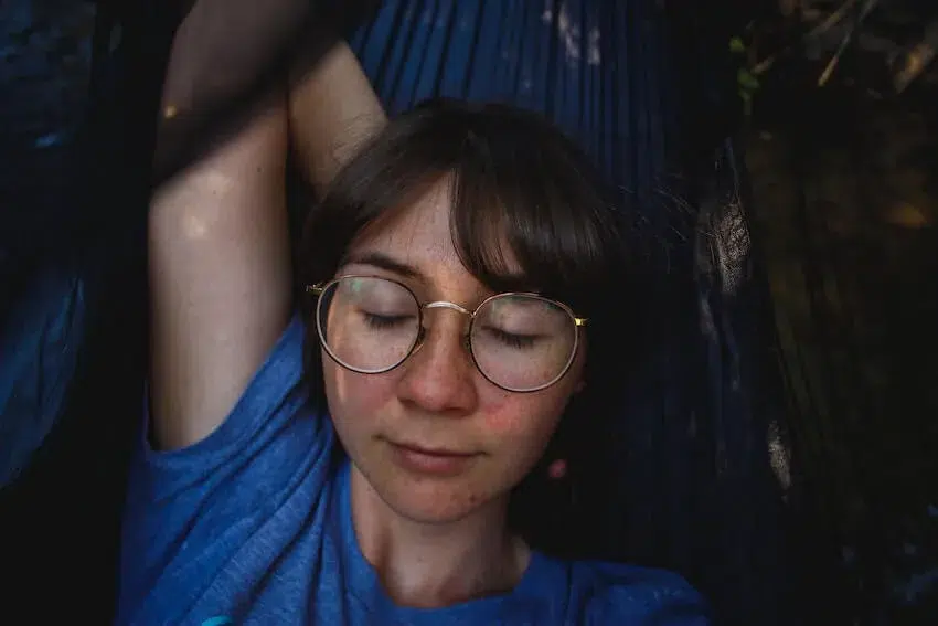 woman in glasses laying on the ground resting her head on her right hand during a moment of acceptance