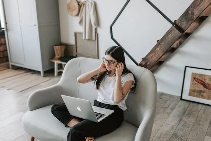 Woman sitting in her living room working on her laptop