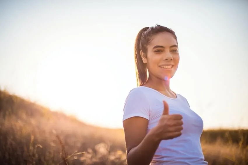 a smiling woman giving a thumbs up