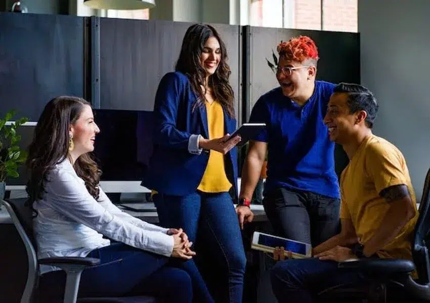 colleagues discussing while holding tablets
