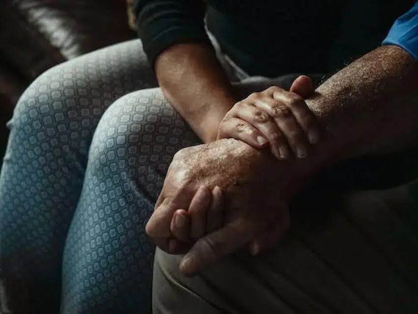 a woman holding someone's arm, comforting them
