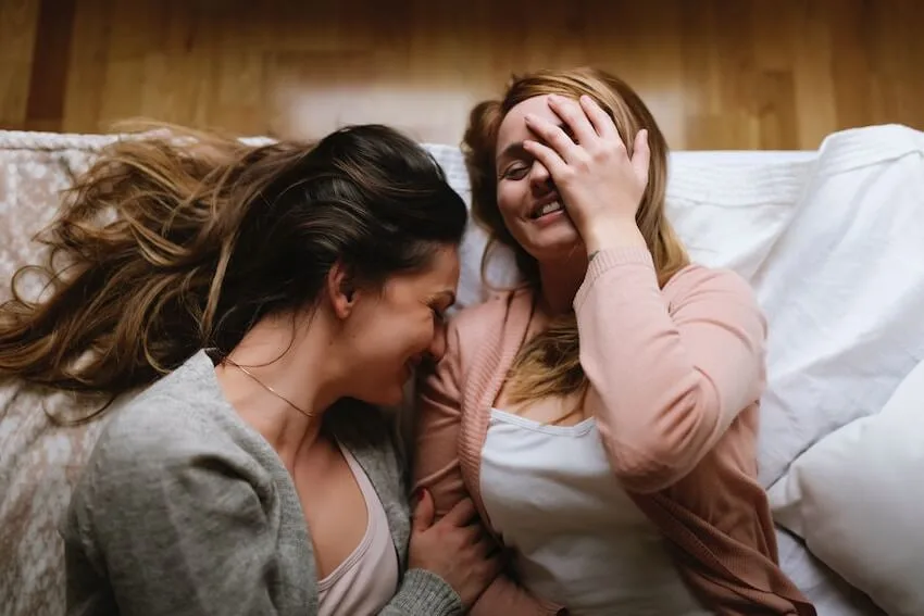 a couple laying in bed laughing