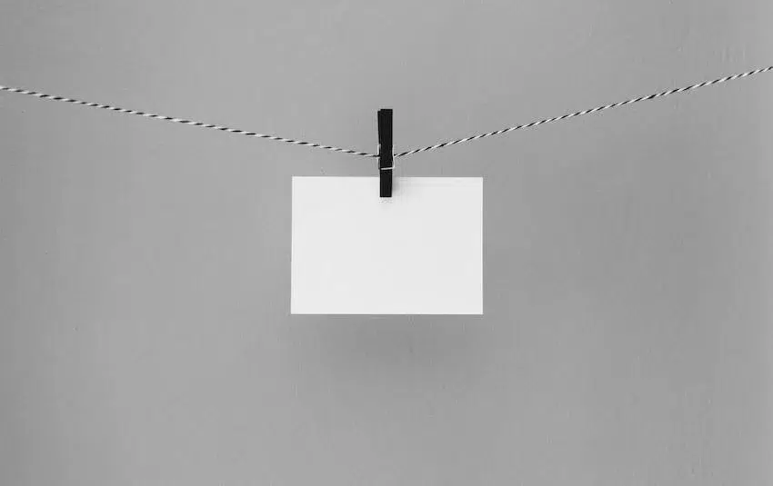 a blank sheet of paper hanging by a clothespin on a line