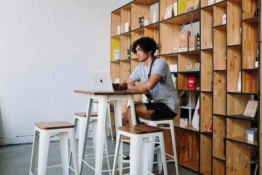 Man sitting at a table working on his laptop