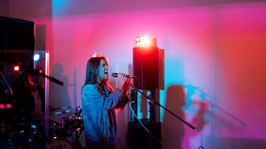 woman singing into a microphone at a karaoke venue