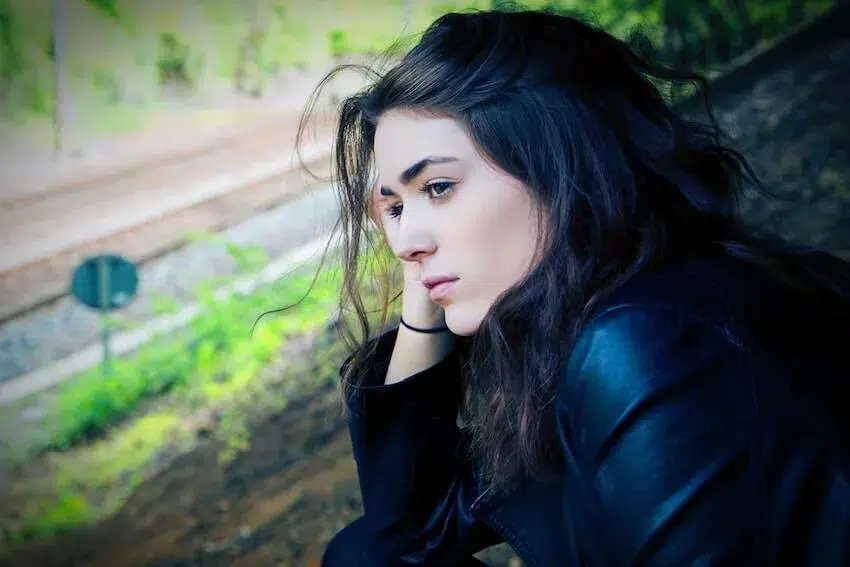 a lonely woman resting her head on her right hand