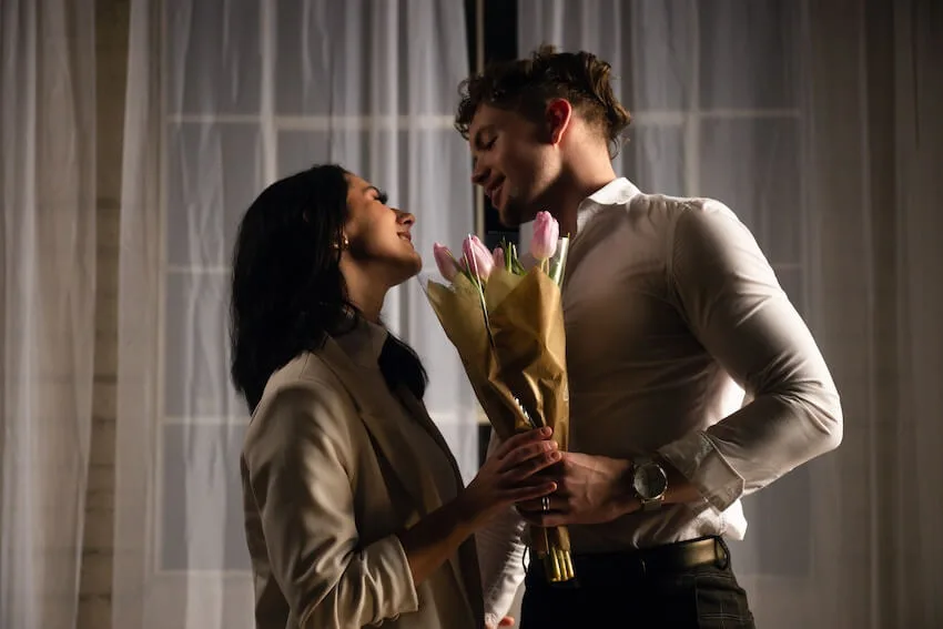 man gifting flowers to a woman