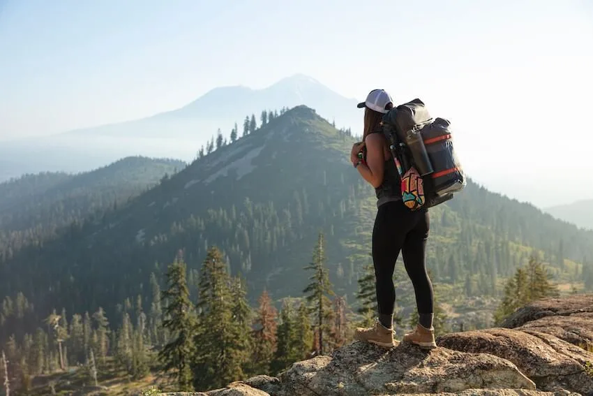 female hiker with a large backpack admiring the view