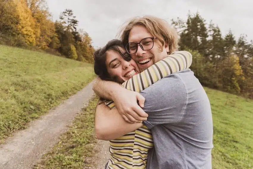 two smiling friends in a happy embrace