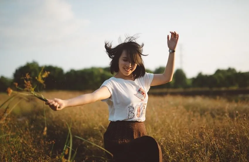 happy woman dancing in a field