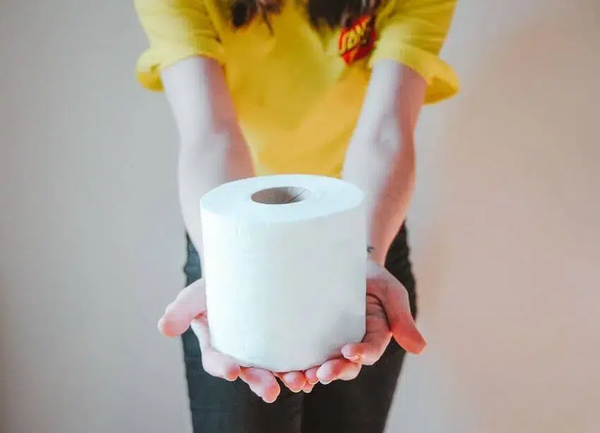a woman presenting a roll of toilet paper