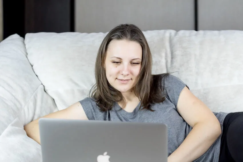 smiling woman typing on her laptop