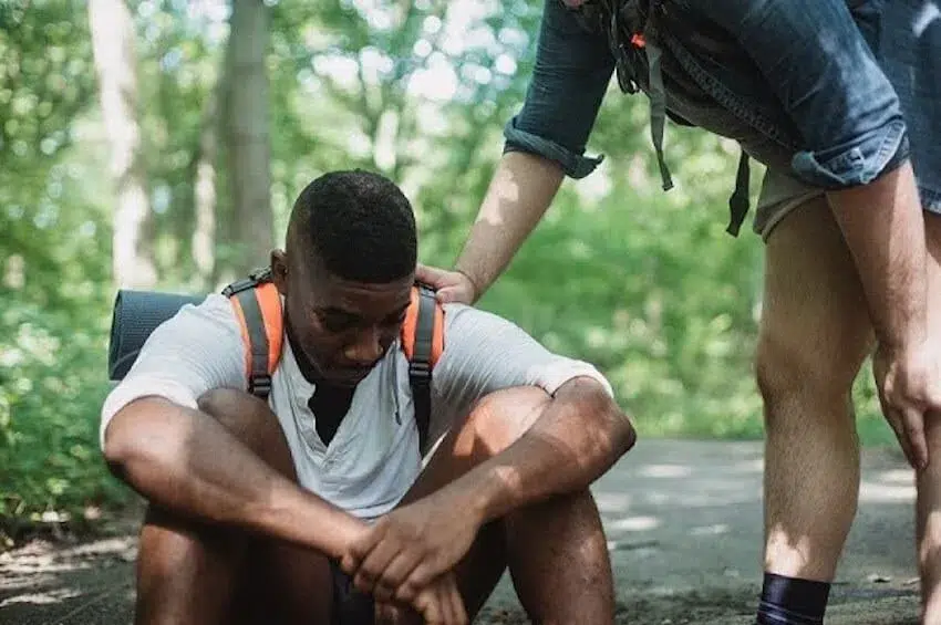 man comforting another that's sitting down